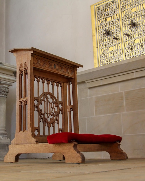 A wooden bench in front of a window with the time of 12 : 30.