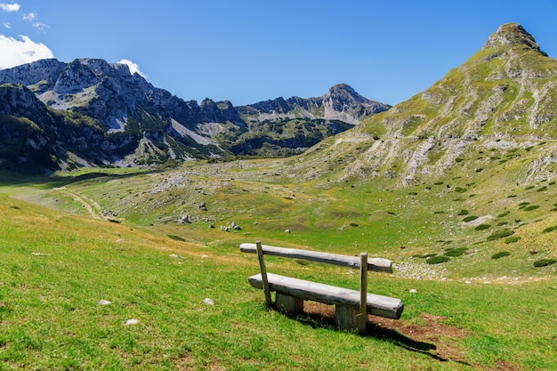 Wooden bench on a hill overlooking the mountain range and the road Beautiful landscape