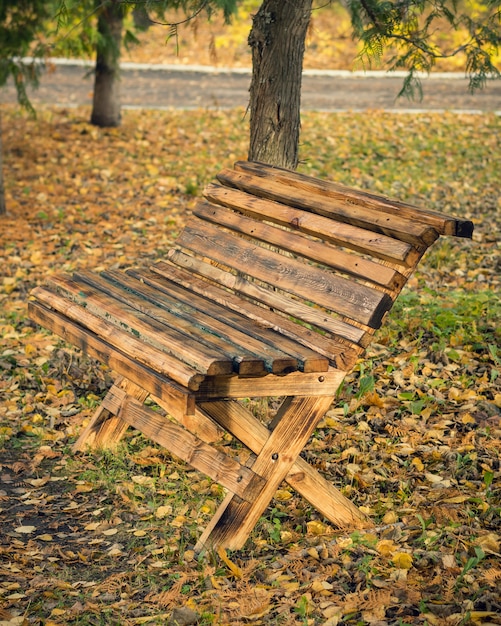 Panca in legno realizzata a casa nel parco in autunno.