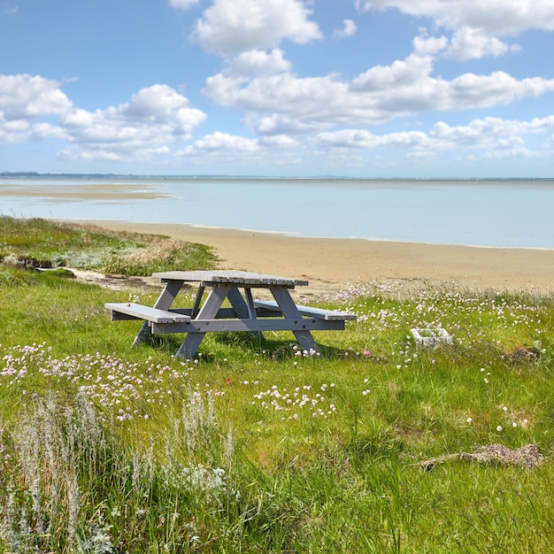 Wooden bench and table by the East Coast of Jutland Denmark for a picnic by the sea outside Seating furniture at the beach to enjoy a meal at while taking a break and rest from travel and exploring