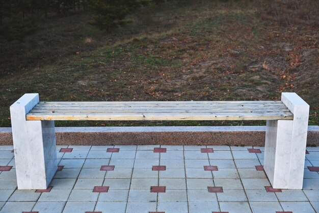 Wooden bench with marble legs in a public Park.