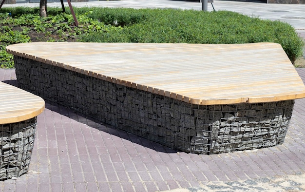 Wooden benches from gabion baskets with stones inside Wood mounted on gabions Benches of modern design Detail of a low woodtopped gabion wall for use as a bench