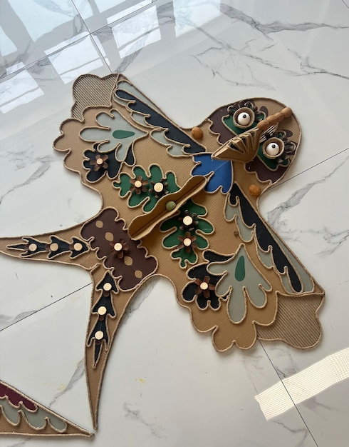 A wooden bird with a blue bird on it.