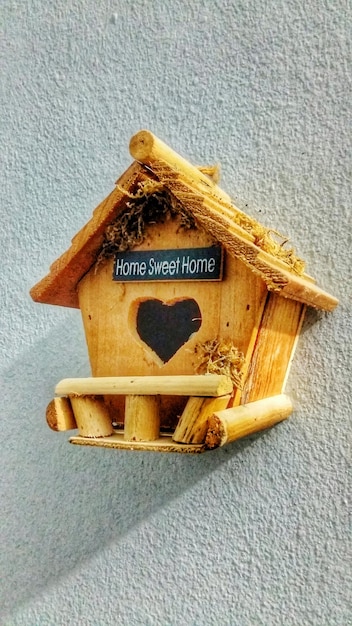 Фото Деревянный птичий домик, установленный на стене