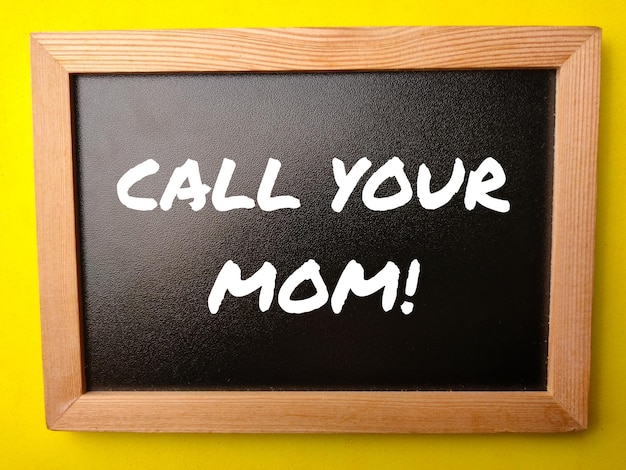 「CALL YOUR MOM」という言葉が書かれた木製の黒板