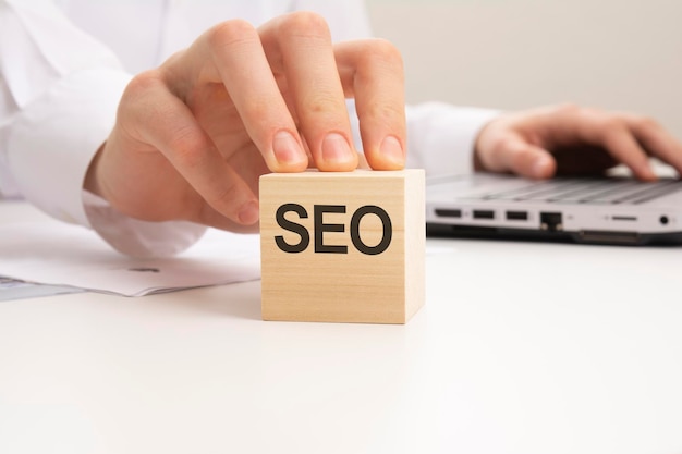 白い背景に SEO の文字が書かれた木製のブロック SEO Search Engines Optimization の略