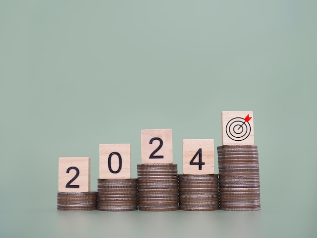 Wooden block with number 2024 on stack of coins The concept of saving money for business achievement goal Financial Investment and Business growing in new year 2024