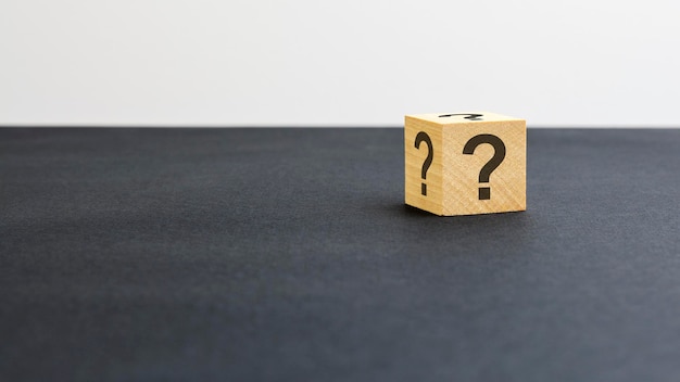 Wooden block with question marks on black background business teamwork concept