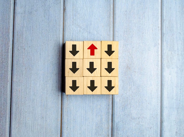 Wooden block with red arrow facing the opposite direction black arrows