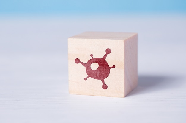 Wooden block with a virus icon.