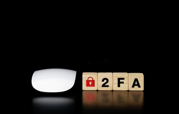 Wooden block with the word 2FA and a mouse on a dark background. 2FA two-factor authentication,