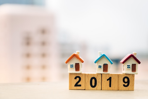 Photo wooden block word 2019 new year and house on top of coins stack.