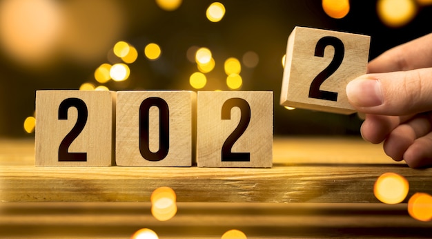 Wooden blocks 2022 2021 on table. Happy New Year concept photo, background with bokeh