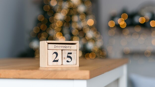 Wooden blocks calendar with the date of december  on the christmas lights bokeh background