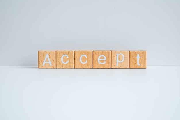 Wooden blocks form the text Accept against a white background