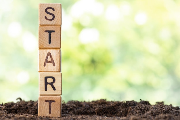 Wooden blocks lie on a wooden table against the backdrop of a summer garden and create the word STAR