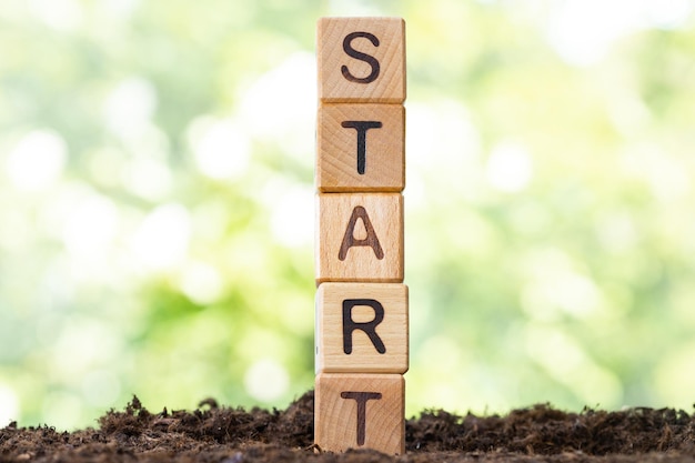 Wooden blocks lie on a wooden table against the backdrop of a summer garden and create the word STAR