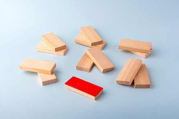 Wooden blocks in pairs and one red as symbol of love couple and single, bachelor. Diversity and ndividuality and uniqueness. Concept of exclusion, loneliness, difference, discrimination.