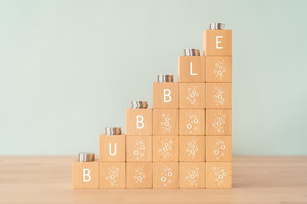 Wooden blocks with BUBBLE text of concept and coins.