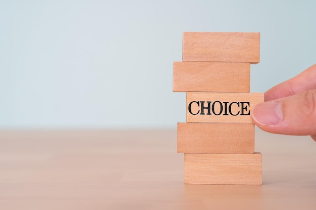 Wooden blocks with CHOICE text of concept and a hand.