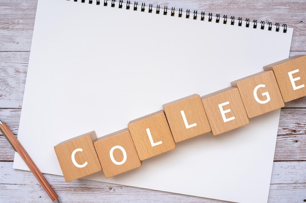 写真 コンセプトのcollegeテキスト、ペン、ノートが入った木製のブロック。