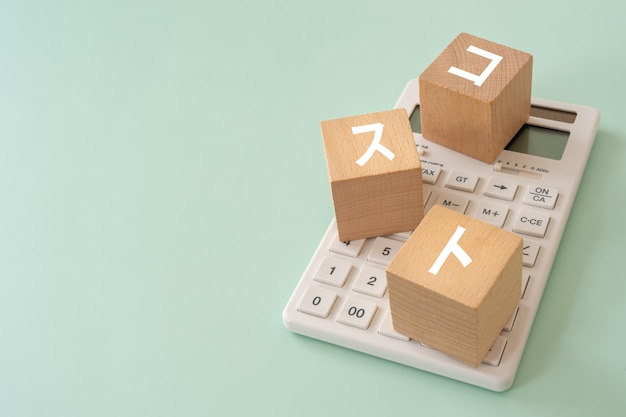 Wooden blocks with cost text of concept and a calculator