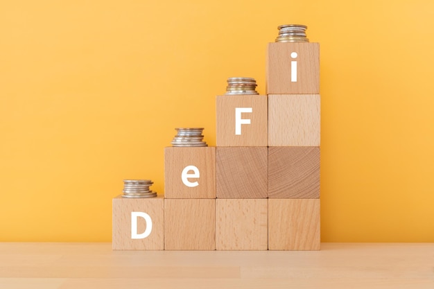 Wooden blocks with DeFi text of concept and coins.