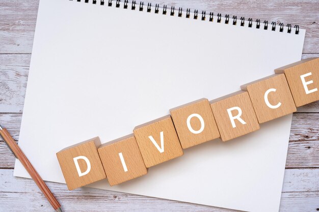 DIVORCE コンセプトのテキスト、ペン、ノートが入った木製のブロック。