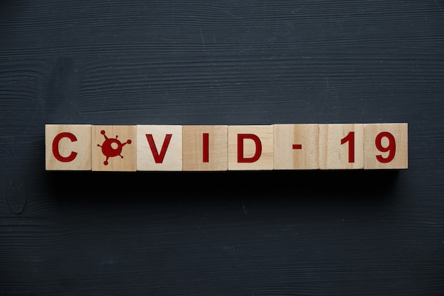 Wooden blocks with the inscription coronavirus - COVID-19 and icon. Top view.