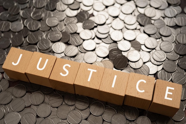 Wooden blocks with JUSTICE text of concept and coins.