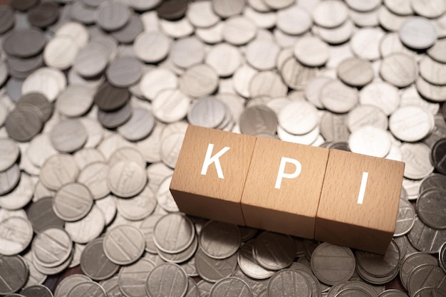Wooden blocks with KPI text of concept and coins.