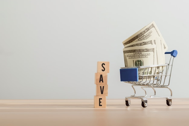 Wooden blocks with 'save' text and dollars on the cart