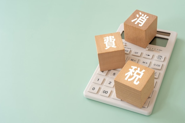 Wooden blocks with shohizei text of concept and a calculator