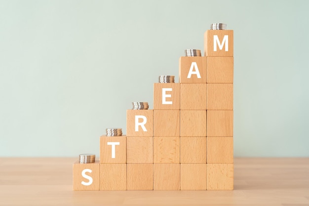 Wooden blocks with STREAM text of concept and coins.