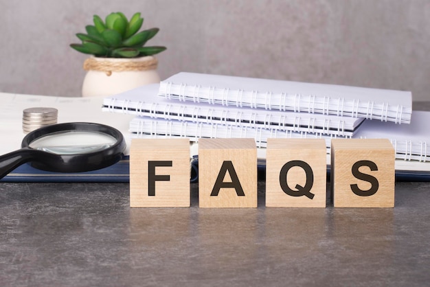 Wooden blocks with text FAQS on black table