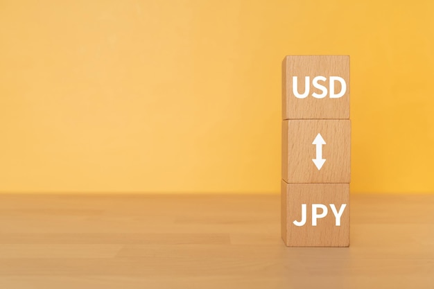 Деревянные блоки с текстом концепции в долларах США и иенах.