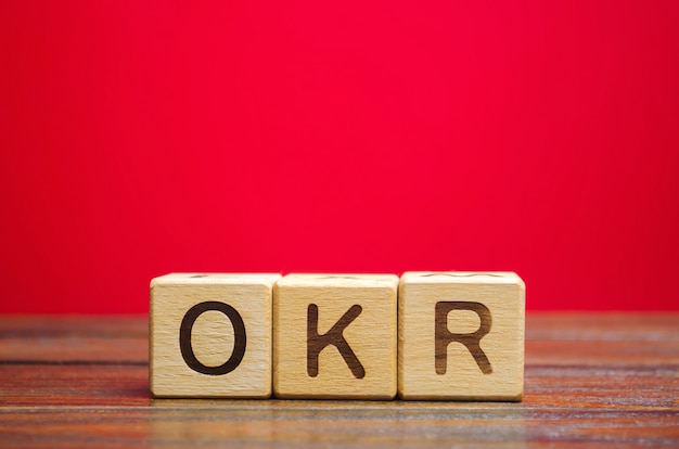 Wooden blocks with the word okr ( objectives and key results ). team and individual goals.