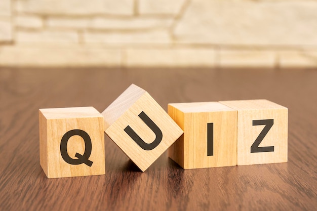 Wooden blocks with word QUIZ on dark wooden background frequently asked question concept