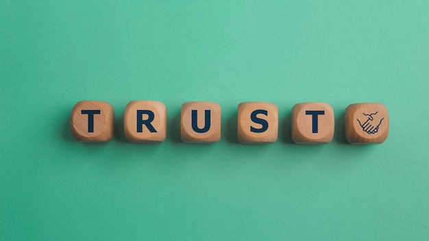 wooden blocks with the word trust trust relationships between business partners friends and relatives respect and authority confidence in a person reliable partner