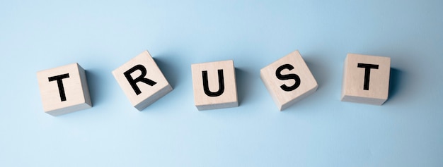 Wooden blocks with the word Trust. Trust relationships between business partners, friends, relatives.