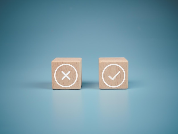 Wooden blocks with wrong and right symbols on light blue background