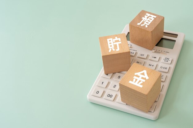 Wooden blocks with yochokin text of concept and a calculator