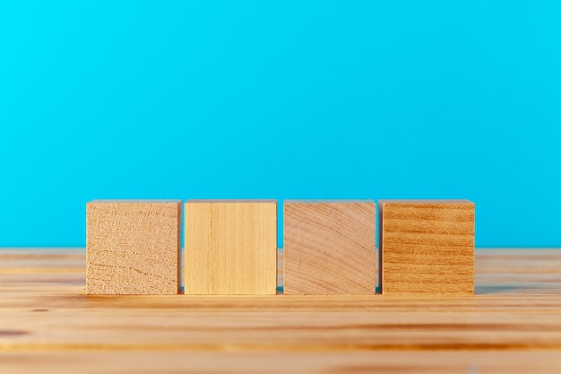 Wooden blocks on wooden desk against blue background, copy space