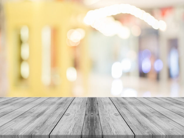 Wooden board empty table blur in coffee shop background.