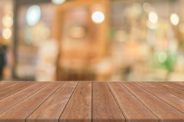 Photo wooden board empty table in front of blurred coffee shop background.