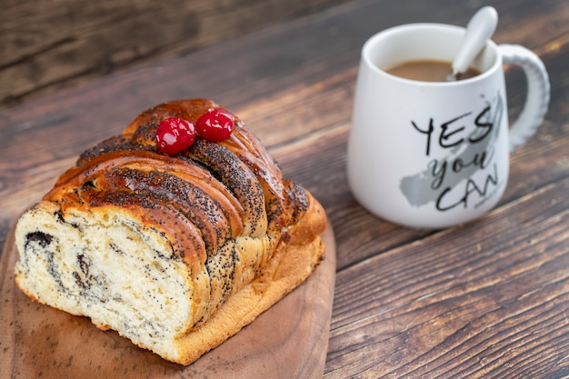 Wooden board of fresh pastry with chocolate and coffee on wooden table. 