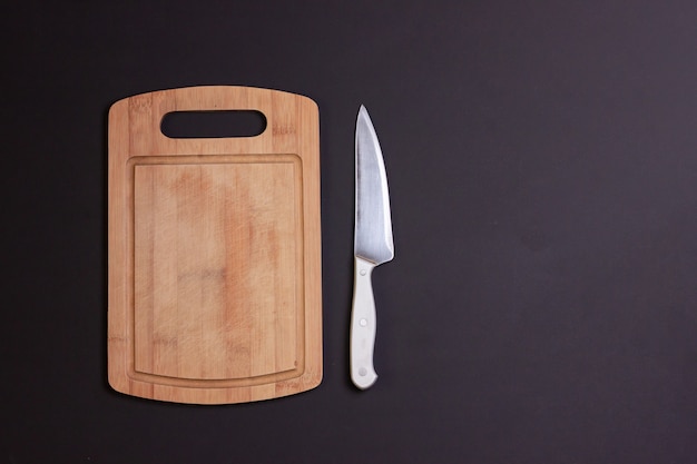 A wooden board and a metal knife with a plastic handle