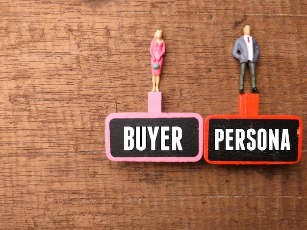 木の板と木製の背景にテキスト BUYER PERSONAL を持つミニチュアの人々