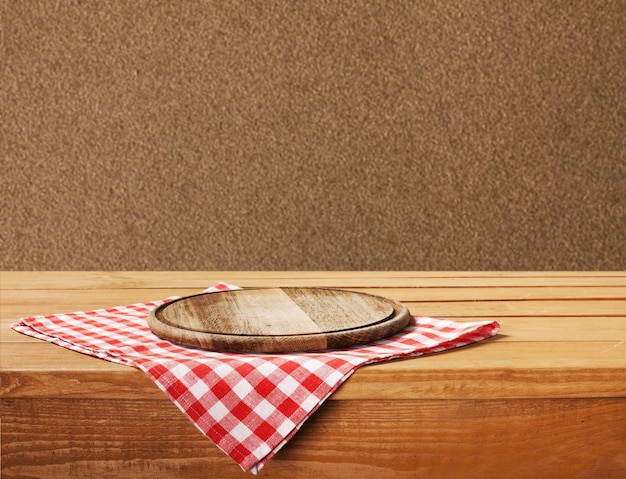 Wooden board stand on tablecloth over grunge background