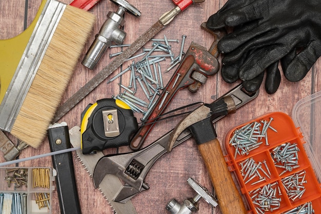 Foto su una tavola di legno sono disposti in modo irregolare una varietà di strumenti necessari per la riparazione della casa